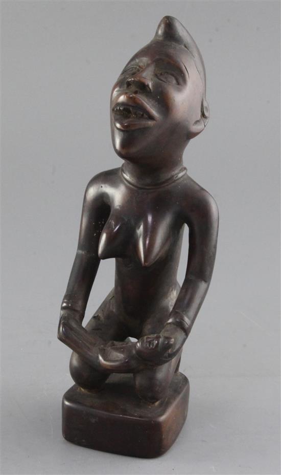 An African hardwood group of a kneeling woman holding an infant, 26cm